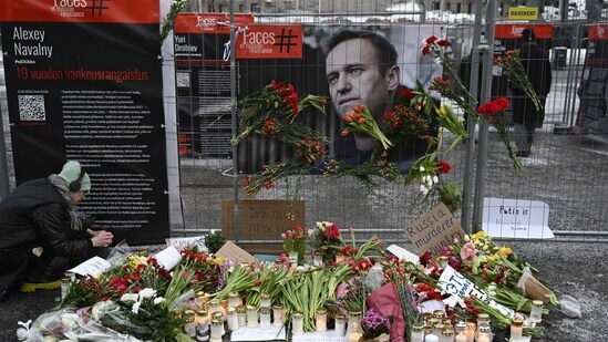 Candles and flowers are brought to a makeshift memorial. (AFP)