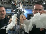 The image shows an astronaut aboard the ISS squeezing a wet towel. The image shows an astronaut aboard the ISS squeezing a wet towel.