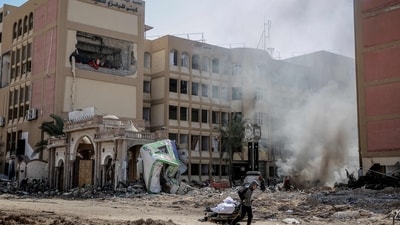 A young Palestinian pulls a wheel cart past the heavily damaged building of Al-Azhar University in Gaza City on February 15, 2024, amid the continuing war between Israel and the Palestinian Hamas movement. (Photo by AFP) (AFP) A young Palestinian pulls a wheel cart past the heavily damaged building of Al-Azhar University in Gaza City on February 15, 2024, amid the continuing war between Israel and the Palestinian Hamas movement. (Photo by AFP) (AFP)