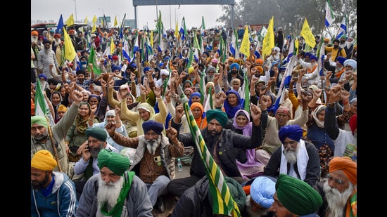 Farmers listen to a leader at the Punjab-Haryana Shambhu border during their 'Delhi Chalo' protest, near Patiala district, on Sunday. (PTI)