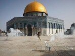 Palestinian man runs away from tear gas during clashes with Israeli security forces in the Al Aqsa Mosque compound in Jerusalem's Old City.