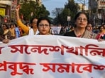People hold a banner during a protest march against Sandeshkhali case, in Kolkata. People hold a banner during a protest march against Sandeshkhali case, in Kolkata.
