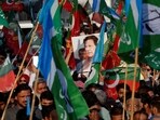 A portrait of the former Prime Minister Imran Khan is seen amid flags of Pakistan Tehreek-e-Insaf (PTI) and the religious and political party Jamat-e-Islami (JI) as supporters attend a joint protest in Karachi on February 10.