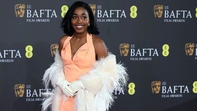 Ayo Edebiri in Bottega Veneta attended the BAFTA Awards 2024 on Sunday in London. She styled the coral pink gown with white fur draped on her shoulder, matching gloves, diamond earrings, side-parted open locks, and striking glam.&nbsp; (REUTERS)