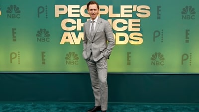 Tom Hiddleston made a dapper appearance on the People's Choice Awards red carpet in a grey checkered suit with a notch lapel blazer, fitted pants, matching tie, and crisp white button-down shirt. Black dress shoes, a backswept hairdo, and a clean-shaved look brought the attire together. (AFP) Tom Hiddleston made a dapper appearance on the People's Choice Awards red carpet in a grey checkered suit with a notch lapel blazer, fitted pants, matching tie, and crisp white button-down shirt. Black dress shoes, a backswept hairdo, and a clean-shaved look brought the attire together. (AFP)