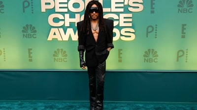 Lenny Kravitz's rockstar look for the People's Choice Awards turned heads on the red carpet. He chose a structured black blazer and skinny-fit black leather pants. Futuristic sunglasses, a necklace, black leather gloves and boots completed the look. (AFP) Lenny Kravitz's rockstar look for the People's Choice Awards turned heads on the red carpet. He chose a structured black blazer and skinny-fit black leather pants. Futuristic sunglasses, a necklace, black leather gloves and boots completed the look. (AFP)