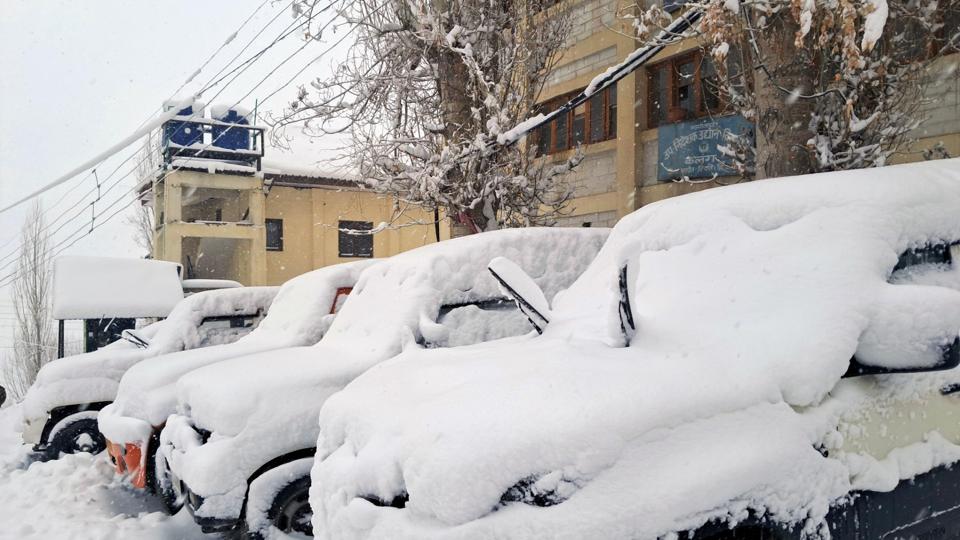 Vehicles covered in snow after a heavy spell in Keylong on Monday. (Aqil Khan/HT)