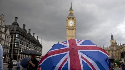 A pedestrian shelters from the rain beneath a Union flag themed umbrella. (AFP) A pedestrian shelters from the rain beneath a Union flag themed umbrella. (AFP)