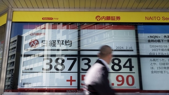 A pedestrian in front of an electronic stock board showing the Nikkei 225 Stock Average outside a securities firm in Tokyo, Japan, on Friday, Feb. 16, 2024. Japanese stock prices are within sight of a historic peak reached during the nation�s economic heyday in 1989 as global investors return in droves. Photographer: Kosuke Okahara/Bloomberg (Bloomberg)