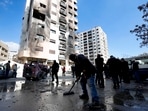 A man sweeps rubble near a residential building after a reported Israeli attack on Syria, according to The Syrian state TV.