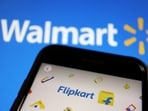 A mobile phone showing an image of Indian online retailer Flipkart is seen in front of a Walmart Inc logo displayed.