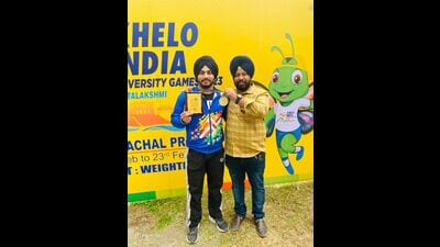 Panjab University weightlifter Gurkaran Singh with coach Karanbir Buttar after winning gold medal in 81kg category at Khelo India University Games at Itanagar. (HT Photo)