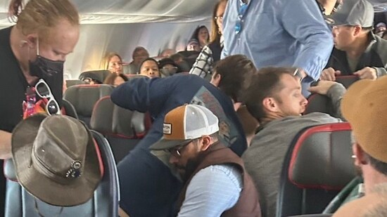 A disruptive passenger on an American Airlines flight was subdued and tackled to the floor when he attempted, and briefly succeeded, in opening the aircraft's emergency door, as captured in a video. (X)