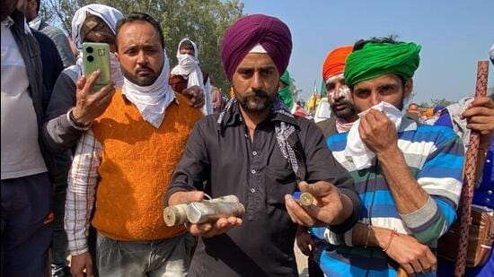 Protesting farmers holding tear gas shells at Khanauri on the Haryana-Punjab interstate border. (HT Photo)