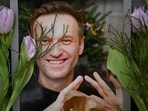 Flowers are seen placed around portraits of late Russian opposition leader Alexei Navalny, who died in a Russian Arctic prison, at a makeshift memorial in front of the former Russian consulate in Frankfurt am Main, western Germany, on February 20, 2024 (Photo by AFP)