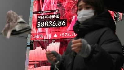 A person walks in front of an electronic stock board showing Japan's Nikkei 225 index at a securities firm in Tokyo. (AP) A person walks in front of an electronic stock board showing Japan's Nikkei 225 index at a securities firm in Tokyo. (AP)