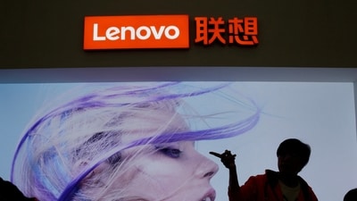 An employee gestures next to a Lenovo logo at Lenovo Tech World in Beijing, China. (Reuters)