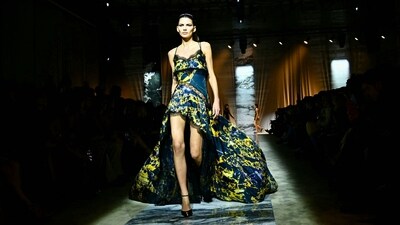A model walks the runway in a glamorous gown with an uneven hemline during the Roberto Cavalli collection show at Milan Fashion Week. She was presenting the Autumn/Winter 2024-2025 womenswear collection. Her mesmerising outfit comes in a variety of colours, with shades of green, blue and black adding a splash of contrast. The sweetheart neckline and extended fabric at the back added a touch of glamour. (Photo by GABRIEL BOUYS / AFP) A model walks the runway in a glamorous gown with an uneven hemline during the Roberto Cavalli collection show at Milan Fashion Week. She was presenting the Autumn/Winter 2024-2025 womenswear collection. Her mesmerising outfit comes in a variety of colours, with shades of green, blue and black adding a splash of contrast. The sweetheart neckline and extended fabric at the back added a touch of glamour. (Photo by GABRIEL BOUYS / AFP)