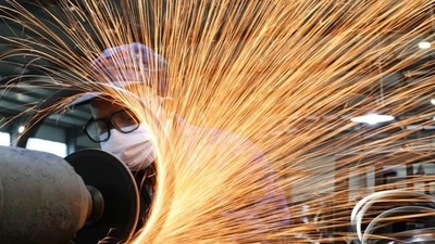 A worker wearing a face mask works on a production line manufacturing. (Reuters/ File photo)