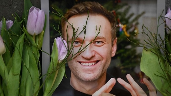 Flowers are seen placed around portraits of late Russian opposition leader Alexei Navalny, who died in a Russian Arctic prison, at a makeshift memorial in front of the former Russian consulate in Frankfurt am Main, western Germany, on February 20, 2024 (Photo by AFP) (AFP)