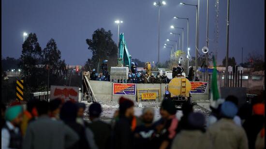 Farmers stand in front of police barricades as they march towards New Delhi to push for better crop prices promised to them in 2021, at Shambhu Barrier, the border between Punjab and Haryana states, on February 22. (REUTERS)