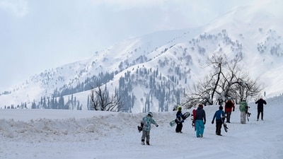 People walk through the snow in Gulmarg, J&K. (AFP)