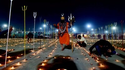 A Sadhu performs ritual as Hindu devotees light oil lamps near stands tridents ('trishul') at a religious event organised on the eve of Maghi Purnima, during the Magh Mela festival in Prayagraj. (PTI) A Sadhu performs ritual as Hindu devotees light oil lamps near stands tridents ('trishul') at a religious event organised on the eve of Maghi Purnima, during the Magh Mela festival in Prayagraj. (PTI)