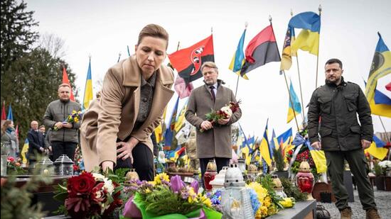 Denmark's Prime Minister Mette Frederiksen (C), her husband Bo Tengberg (C) and Ukraine's President Volodymyr Zelensky (R) arrive to lay flowers during a memorial ceremony at the Field of Mars of Lychakiv Cemetery, in Lviv, on February 23, 2024. (AFP)