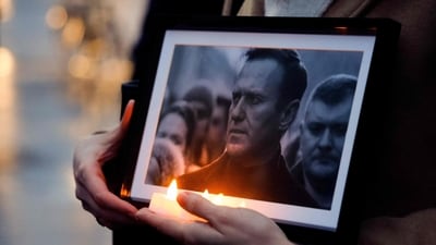A protester holds candles and a picture of the late opposition leader Alexei Navalny during a demonstration in Paris on February 22. (Ludovic MARIN / AFP) A protester holds candles and a picture of the late opposition leader Alexei Navalny during a demonstration in Paris on February 22. (Ludovic MARIN / AFP)