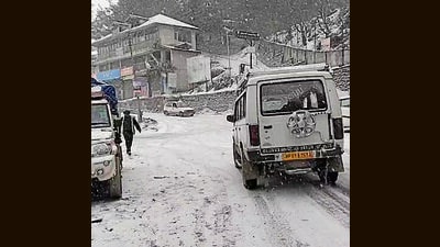 Vehicles plying on a snow-covered road in Kufri (HT Photo)