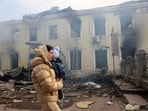 A local resident and her child walks past the railway station destroyed by a Russian missile attack in Konstyantynivka, Donetsk region, on February 25, 2024, amid the Russian invasion of Ukraine. (Photo by Anatolii STEPANOV / AFP)