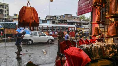 Passing pedestrians and traffic are seen through the window of a leather goods stores in the Dharavi area of Mumbai, India, on Tuesday, July 18, 2017. India's new goods and services tax, introduced on July 1, classified leather products as luxury items and raised the rate to 28 percent -- more than double the 13.5 percent tax levied until June 30. The leather sector is just one example of how India's vast informal economy -- which accounts for more than 90 percent of the workforce -- is struggling under India's new tax rates, which range widely from exemptions for items like basic food grains to 28 percent for products like air conditioners. Photographer: Dhiraj Singh/Bloomberg (Bloomberg) Passing pedestrians and traffic are seen through the window of a leather goods stores in the Dharavi area of Mumbai, India, on Tuesday, July 18, 2017. India's new goods and services tax, introduced on July 1, classified leather products as luxury items and raised the rate to 28 percent -- more than double the 13.5 percent tax levied until June 30. The leather sector is just one example of how India's vast informal economy -- which accounts for more than 90 percent of the workforce -- is struggling under India's new tax rates, which range widely from exemptions for items like basic food grains to 28 percent for products like air conditioners. Photographer: Dhiraj Singh/Bloomberg (Bloomberg)