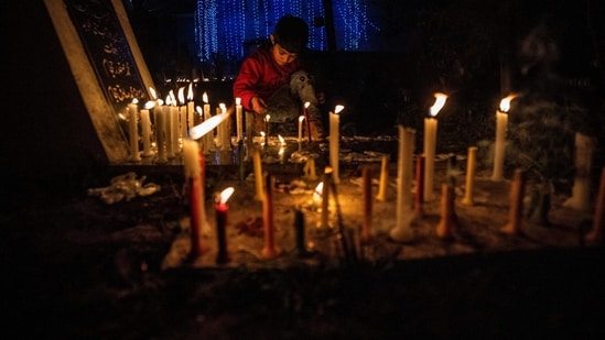 A Kashmiri Shiite Muslim boy lights candles at the grave of his relative to mark ‘Shab-e- Barat’, on the outskirts of Srinagar on Sunday.&nbsp;(AP)