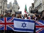 People hold Israeli and British flags during a march against antisemitism in London, November 26, 2023.