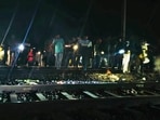 People stand near a railway track where at least two persons were run over and killed by a train near Kaljharia area, in Jamtara district on Feb. 28.