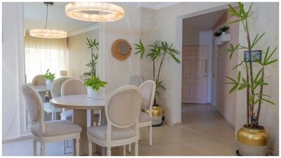 From the moment you step into the home – featuring a big pink door at the entrance – you are welcomed with a calming pink and beige colour palette and plants of different sizes. A corridor featuring pale pink walls, opening out to the dining and living areas, sets the tone for the rest of Ananya Panday's breezy Mumbai home. From the moment you step into the home – featuring a big pink door at the entrance – you are welcomed with a calming pink and beige colour palette and plants of different sizes. A corridor featuring pale pink walls, opening out to the dining and living areas, sets the tone for the rest of Ananya Panday's breezy Mumbai home.