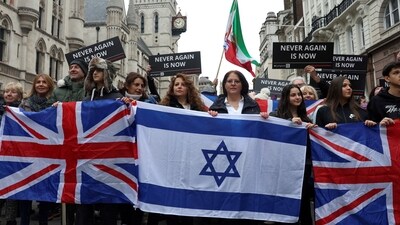 People hold Israeli and British flags during a march against antisemitism in London, November 26, 2023. (Reuters)