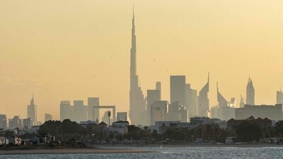 A man and a child ride a personal watercraft near the Dubai skyline featuring the landmark Burj Khalifa skyscraper, the world�s tallest building, on February 13, 2024. (Photo by Giuseppe CACACE / AFP) A man and a child ride a personal watercraft near the Dubai skyline featuring the landmark Burj Khalifa skyscraper, the world�s tallest building, on February 13, 2024. (Photo by Giuseppe CACACE / AFP)