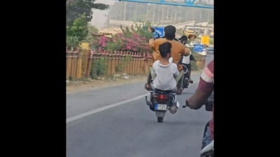 Bengaluru: Men performing wheelie on busy Yelahanka road. (X/@3rdeyedude) Bengaluru: Men performing wheelie on busy Yelahanka road. (X/@3rdeyedude)