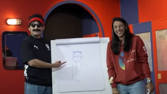 Smriti Mandhana (R) poses with her portrait of Virat Kohli alongside Danish Sait (YouTube)