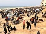  Palestinians gather as they wait for trucks carrying bags of flour to arrive, near an Israeli checkpoint