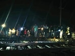 People stand near a railway track where at least two persons were run over and killed by a train near Kaljharia area, in Jamtara district. (PTI)