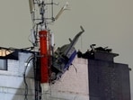 The helicopter hangs from the roof of a building after crashing due to strong winds, according to authorities, in Medellin, Colombia. 