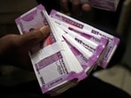 A cashier displays the new 2000 Indian rupee banknotes inside a bank in Jammu.