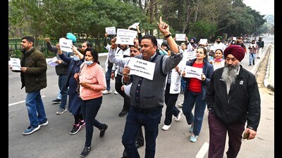 Outsourced health department workers taking out a march to protest against delayed wages in Chandigarh on Friday. (Keshav Singh/HT)