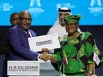 Director-General of the World Trade Organization (WTO) Ngozi Okonjo-Iweala and President of Comoros Azali Assoumani chat after signing the agreement for the Comoros accession to the WTO during the 13th WTO Ministerial Conference in Abu Dhabi of February 26, 2024. The world's trade ministers gathered in the UAE on February 26 for a high-level WTO meeting with no clear prospects for breakthroughs, amid geopolitical tensions and disagreements. (Photo by Giuseppe CACACE / AFP)