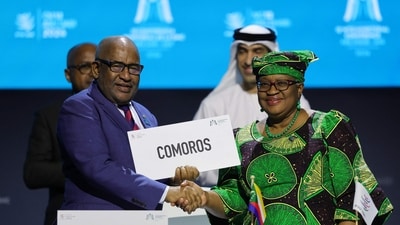 Director-General of the World Trade Organization (WTO) Ngozi Okonjo-Iweala and President of Comoros Azali Assoumani chat after signing the agreement for the Comoros accession to the WTO during the 13th WTO Ministerial Conference in Abu Dhabi of February 26, 2024. The world's trade ministers gathered in the UAE on February 26 for a high-level WTO meeting with no clear prospects for breakthroughs, amid geopolitical tensions and disagreements. (Photo by Giuseppe CACACE / AFP) (AFP)