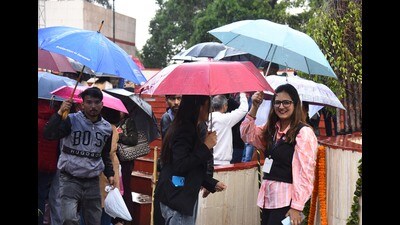 Visitors caught in the rain on the last day of 36th Spring Fest at Town Park, Panchkula, on Sunday. (Sant Arora /HT)