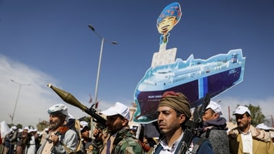 Houthi followers hold a cutout banner, portraying the Galaxy Leader cargo ship which was seized by Houthis, during a parade as part of a 'popular army' mobilization campaign by the movement, in Sanaa, Yemen, February 7, 2024. (Reuters)