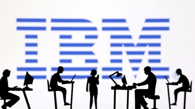 Figurines with computers and smartphones are seen in front of IBM logo. (Reuters)